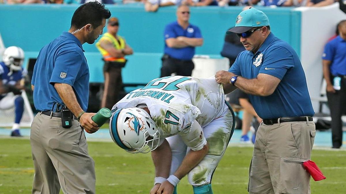 Miami Dolphins quarterback Ryan Tannehill gets assistance from team trainers on the final series in the fourth quarter as they play the Indianapolis Colts at Sun Life Stadium in Miami Gardens on December 27, 2015.