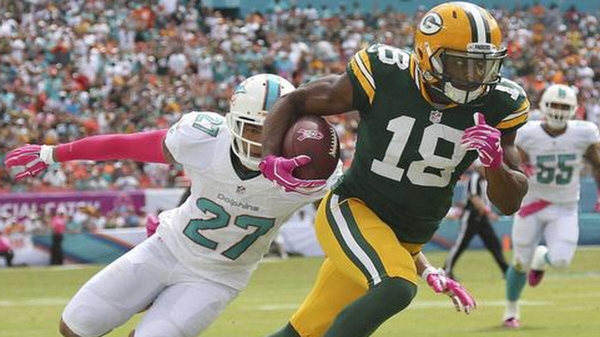
Wide receiver Randall Cobb of the Green Bay Packers runs past safety Jimmy Wilson #27 of the Miami Dolphins at Sun Life Stadium on October 12, 2014 in Miami Gardens, Florida. 
