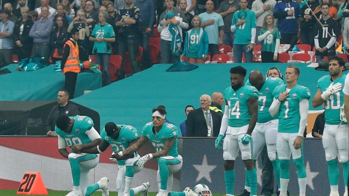 Dolphins Julius Thomas (89), Michael Thomas (31) and Kenny Stills take a knee as the U.S. national anthem is played before the Dolphins 20-0 loss to New Orleans in London, Oct. 1.