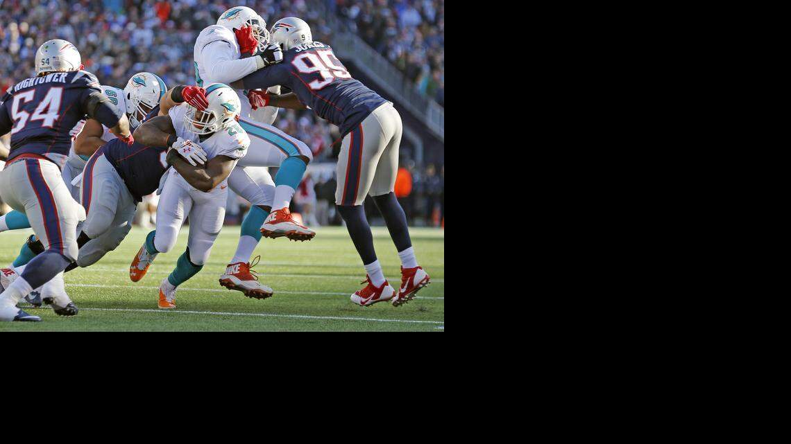 
Miami Dolphins running back Lamar Miller (26) gets stopped short of a touchdown in the third quarter against the New England Patriots at Gillette Stadium in Foxborough, Mass. on Dec. 14, 2014
