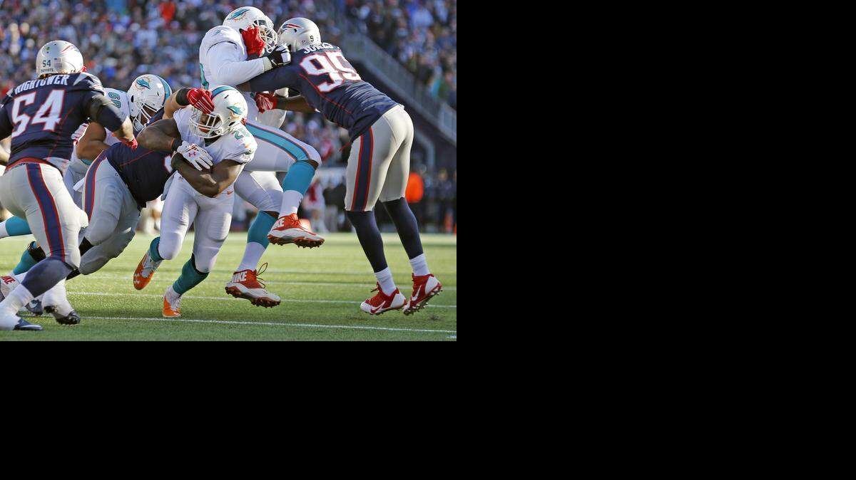 
Miami Dolphins running back Lamar Miller (26) gets stopped short of a touchdown in the third quarter against the New England Patriots at Gillette Stadium in Foxborough, Mass. on Dec. 14, 2014
