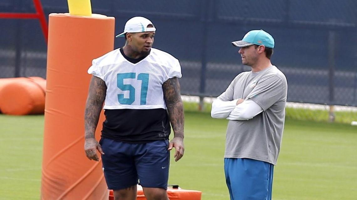 Injured center Mike Pouncey talks with coach Adam Gase during practice at the Miami Dolphins facility in Davie, Florida, September 6, 2016.