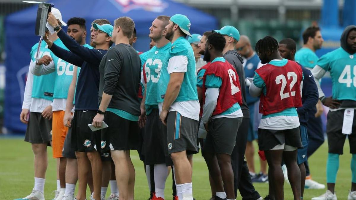 Miami Dolphins players receive instructions during a training session at Allianz Park in London Friday.