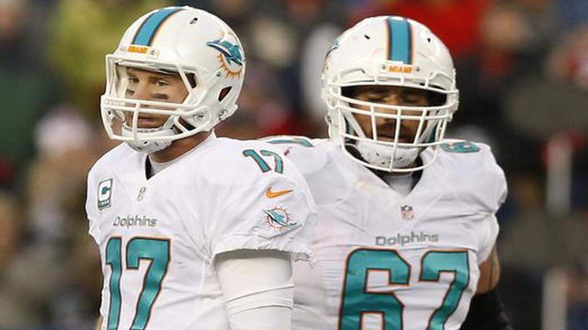 
A dejected Miami Dolphins quarterback Ryan Tannehill (17) and guard Daryn Colledge (67) look on after Tannehill is sacked in the fourth quarter as the New England Patriots host the Miami Dolphins at Gillette Stadium on Sunday, Dec. 14, 2014
