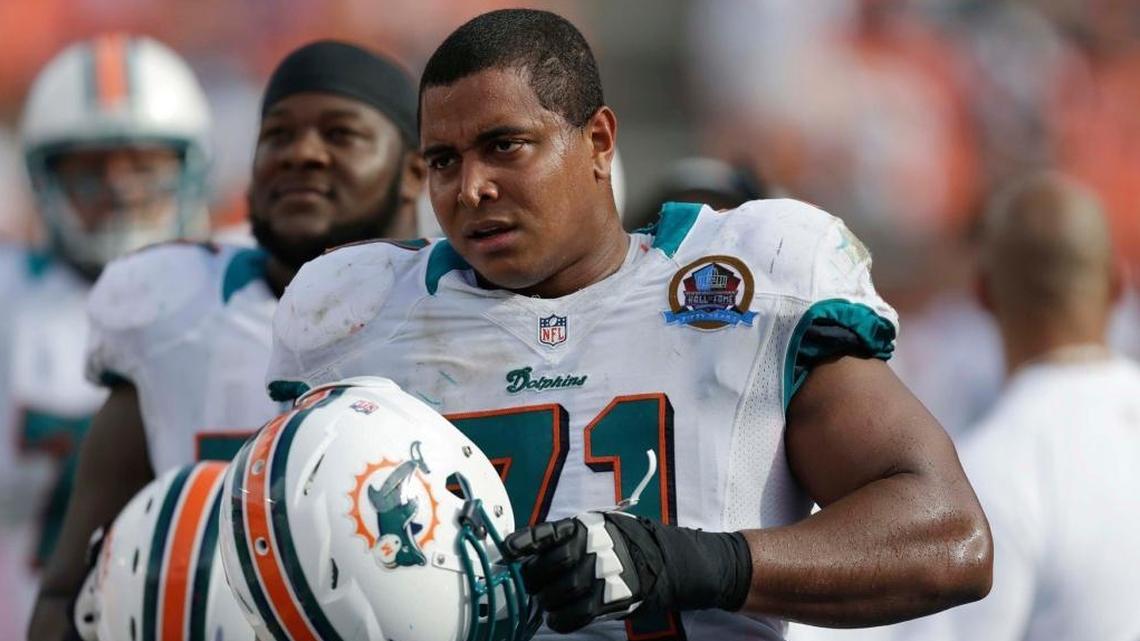 Miami Dolphins tackle Jonathan Martin (71) watches from the sidelines during the second half of an NFL football game against the Jacksonville Jaguars in Miami on Dec. 16, 2012. Martin was taken into police custody on Feb. 23, 2018, after he posted a photo on his Instagram story of a shotgun on a bed with 18 shells sprawled out around it.