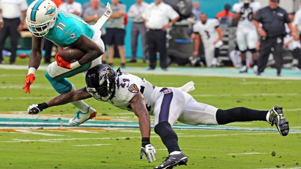 Dolphins DeVante Parker (11) gets hit by the Ravens Brandon Carr (24) in the first quarter as the Miami Dolphins play the Baltimore Ravens in their second preseason game at Hard Rock Stadium in Miami Gardens, FL, Aug. 17, 2017.