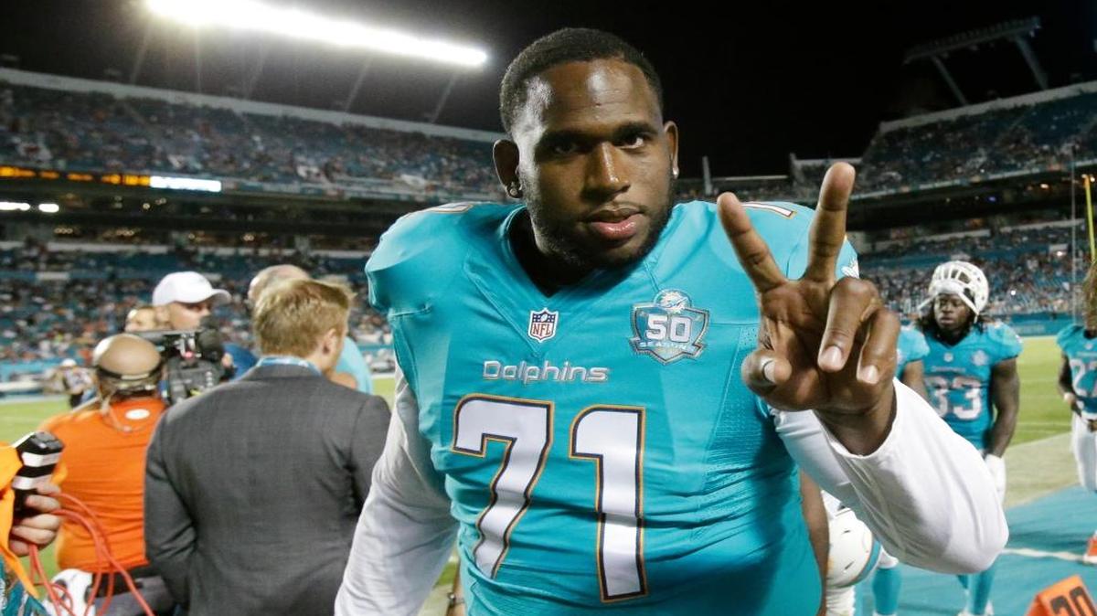 
Miami Dolphins tackle Branden Albert gives a peace sign as he walks off the field after the first half of an NFL preseason football game against the Tampa Bay Buccaneers, Thursday, Sept. 3, 2015 in Miami Gardens, Fla. 
