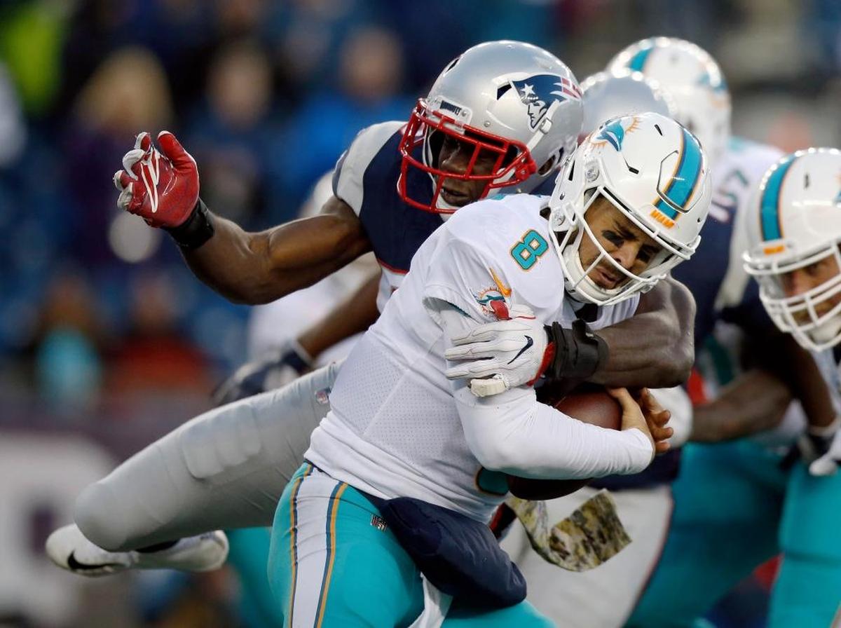 New England Patriots cornerback Jonathan Jones, rear, sacks Miami Dolphins quarterback Matt Moore during the second half of an NFL football game, Sun., Nov. 26, 2017, in Foxborough, Mass.