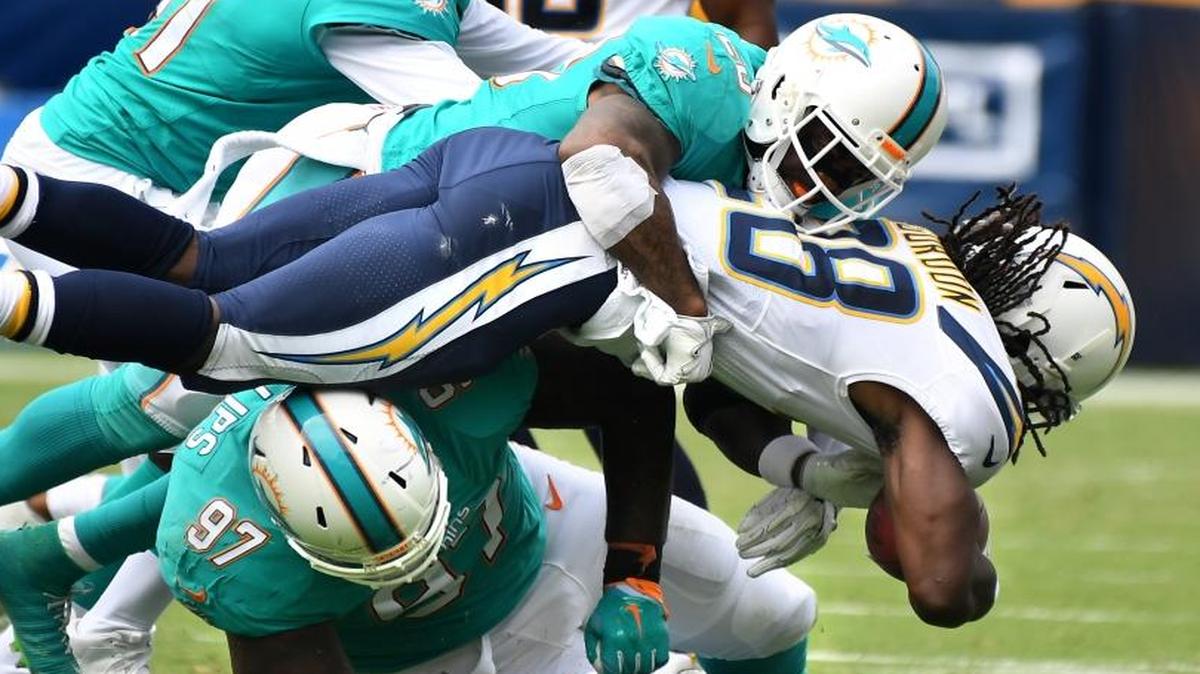 Los Angeles Chargers running back Melvin Gordon is tackled by Miami Dolphins Reshad Jones and Jordan Phillips (97) in the third quarter on Sunday, Sept. 17, 2017 at the StubHub Center in Carson, Calif.