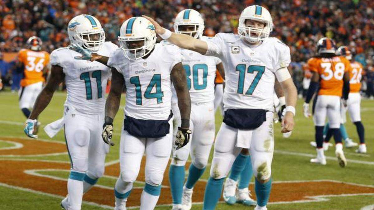 
Miami Dolphins quarterback Ryan Tannehill pats wide receiver Jarvis Landry on the helmet after a third quarter touchdown against the Denver Broncos at Sports Authority Field at Mile High in Denver on Nov. 23, 2014.
