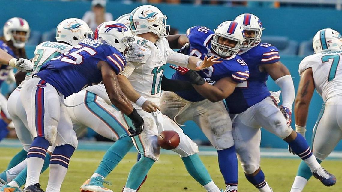 Ryan Tannehill, shown losing the ball against the Bills at Sun Life Stadium on Sept. 27, has struggled against the Bills in Western New York — where Miami plays Sunday — to the point three of his worst games have come there.