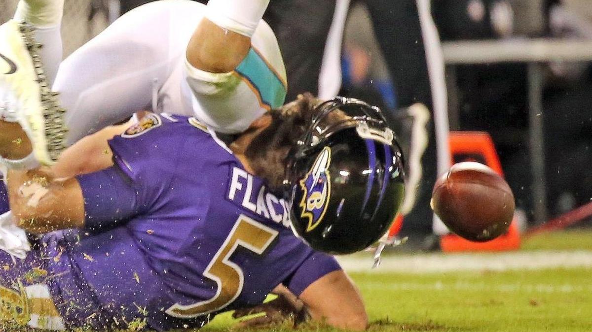 Miami Dolphins Kiko Alonso (47) knocks off and Baltimore Ravens quarterback Joe Flacco (50) helmet in the second quarter at the M&T Bank Stadium in Baltimore, Maryland, Oct. 26, 2017.