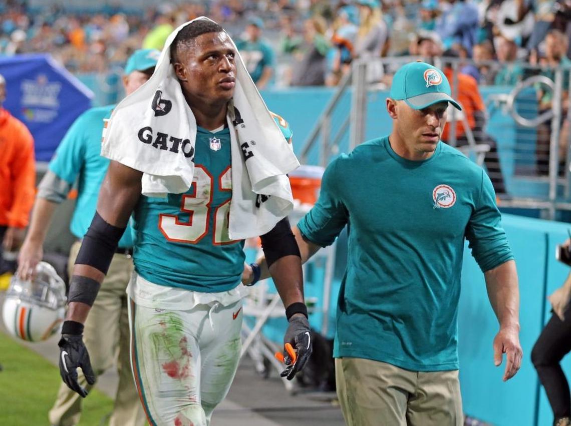 The Dolphins’ Kenyan Drake is escorted off the field after an incident after a play in the fourth quarter against the Buffalo Bills at Hard Rock on Sunday, Dec. 31, 2017.