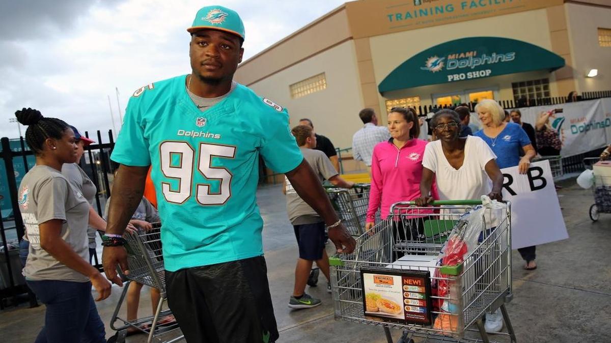 Miami Dolphins Dion Jordan, 95, Defensive End, helps Verdell Matthews pull her cart as the Miami Dolphins distribute 500 Thanksgiving meals to local families in South Florida. The meals were purchased by the players, coaching staff and Hyundai, along with Publix Supermarkets and Feeding South Florida on Wed., Nov. 23, 2016.