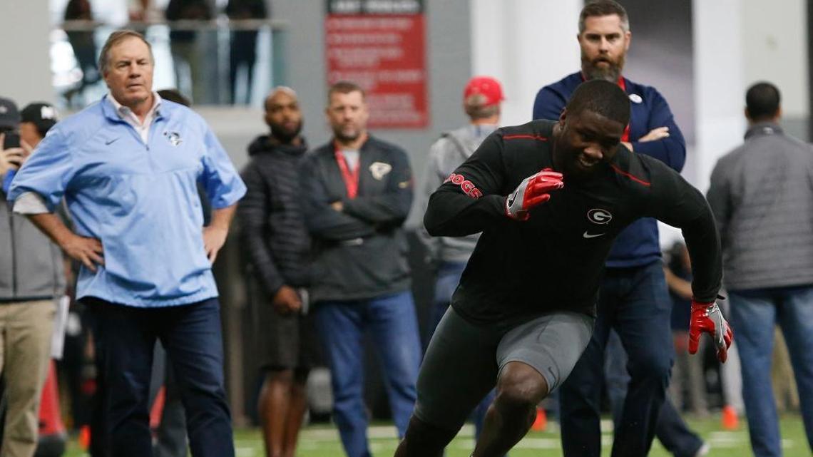 Dolphins defensive coordinator Matt Burke, right, and Patriots head coach Bill Belichick watch Georgia linebacker Roquan Smith (3) run a drill during Georgia’s Pro Day.