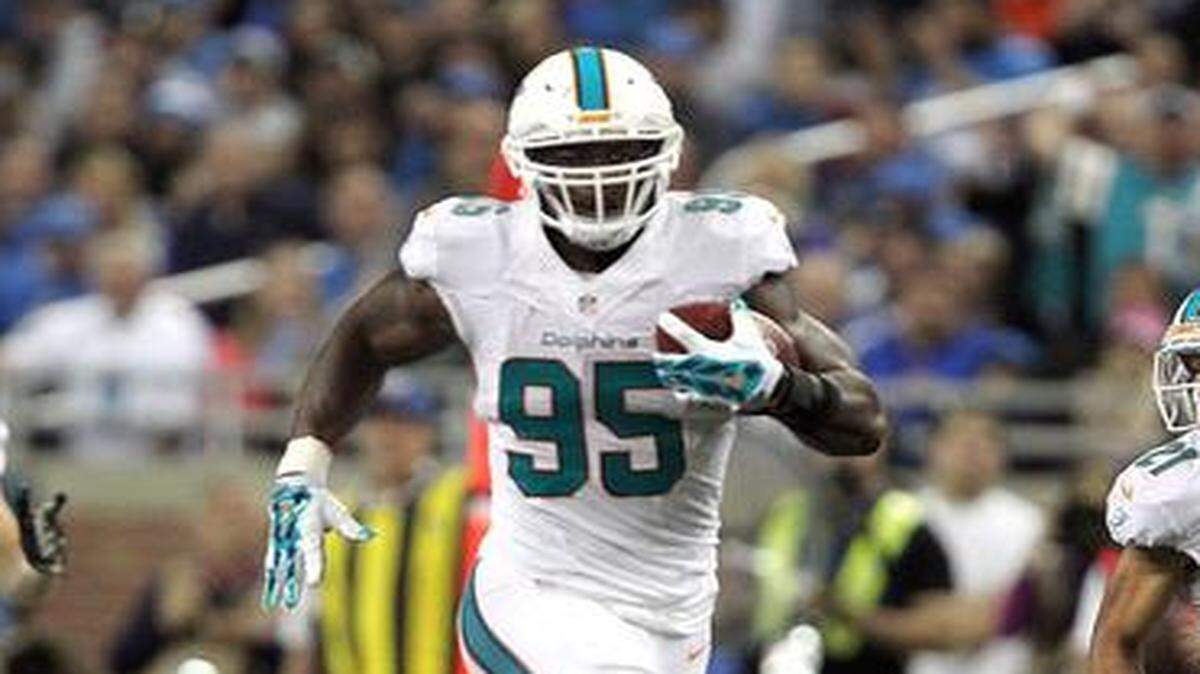 
Miami Dolphins’ Dion Jordan picks up a blocked field goal attempt and runs with the ball in the third quarter to help set up a Dolphins touchdown as they play the Detroit Lions at Ford Field in Detroit on Nov. 9, 2014.
