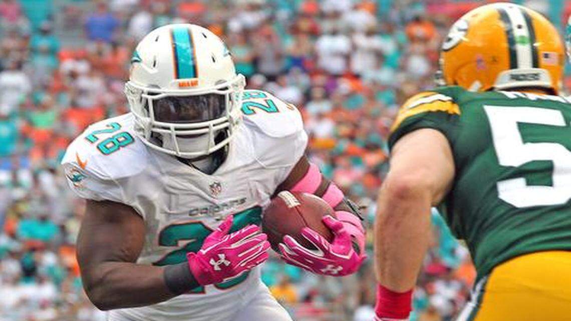 
Miami Dolphins running back Knowshon Moreno runs the ball in the first quarter against the Green Bay Packers at Sun Life Stadium in Miami Gardens on Oct. 12, 2014.
