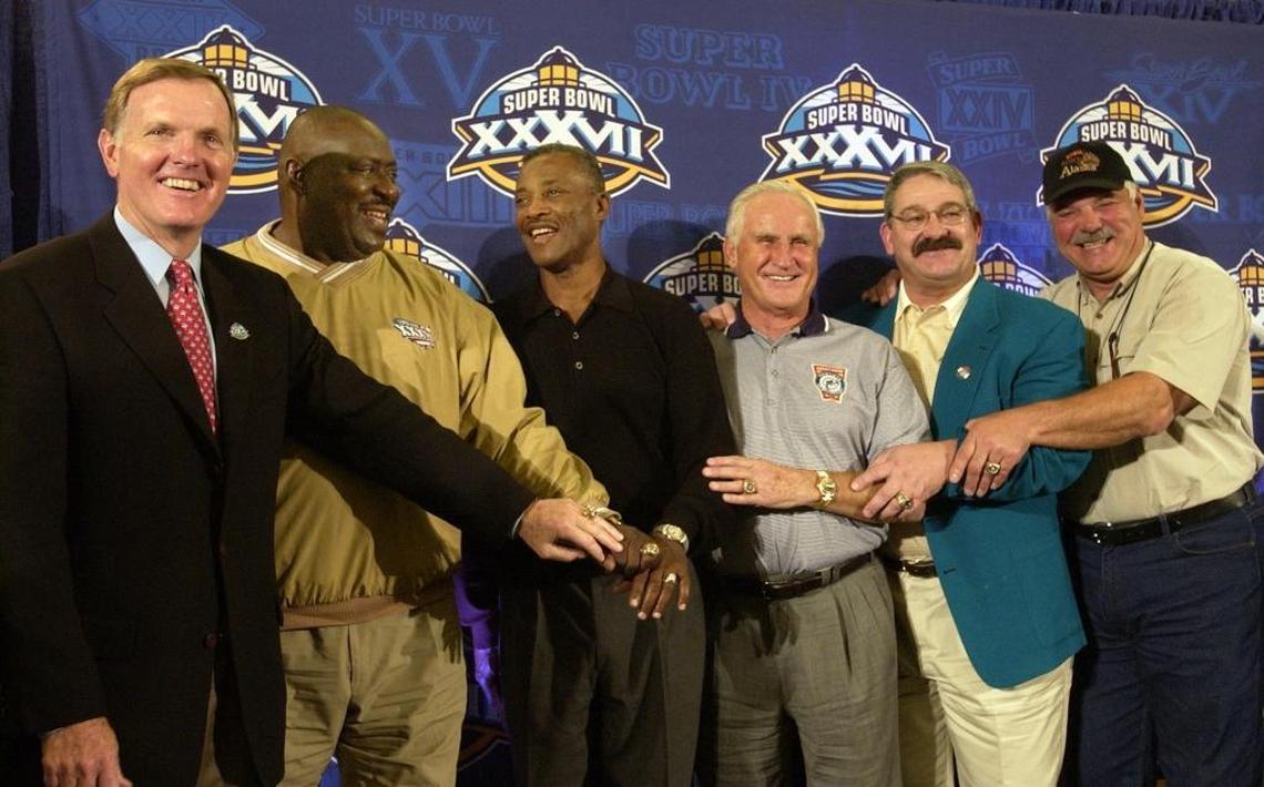 Hall of Famers Bob Griese, left, Larry Little, Paul Warfield, coach Don Shula, Jim Langer and Larry Csonka show off their Super Bowl rings following a news conference on Jan. 24, 2003, in San Diego.