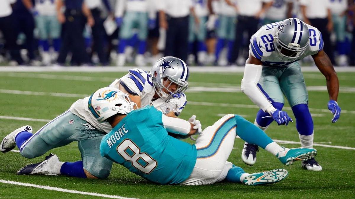 Miami Dolphins' Matt Moore (8) slides to the ground under pressure from Dallas Cowboys' James Morris and Deji Olatoye (29) in the first half of an NFL preseason football game, Fri., Aug. 19, 2016, in Arlington, Texas. Moore left the game with an unknown injury.