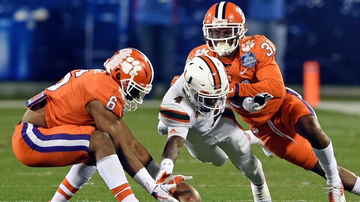 Clemson's Dorian O'Daniel, No. 6, recovers a fumble by Miami's Jeff Thomas, No. 4, as Clemson's Ryan Carter, No. 31, closes in during the second half of the ACC Championship.