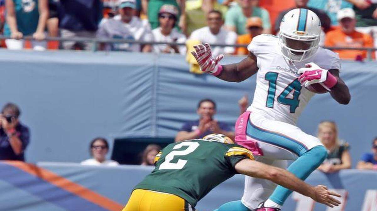 
Miami Dolphins receiver Jarvis Landry leaps over Green Bay Packers kicker Mason Crosby on a kickoff return during the first quarter at Sun Life Stadium in Miami Gardens on Oct. 12, 2014.
