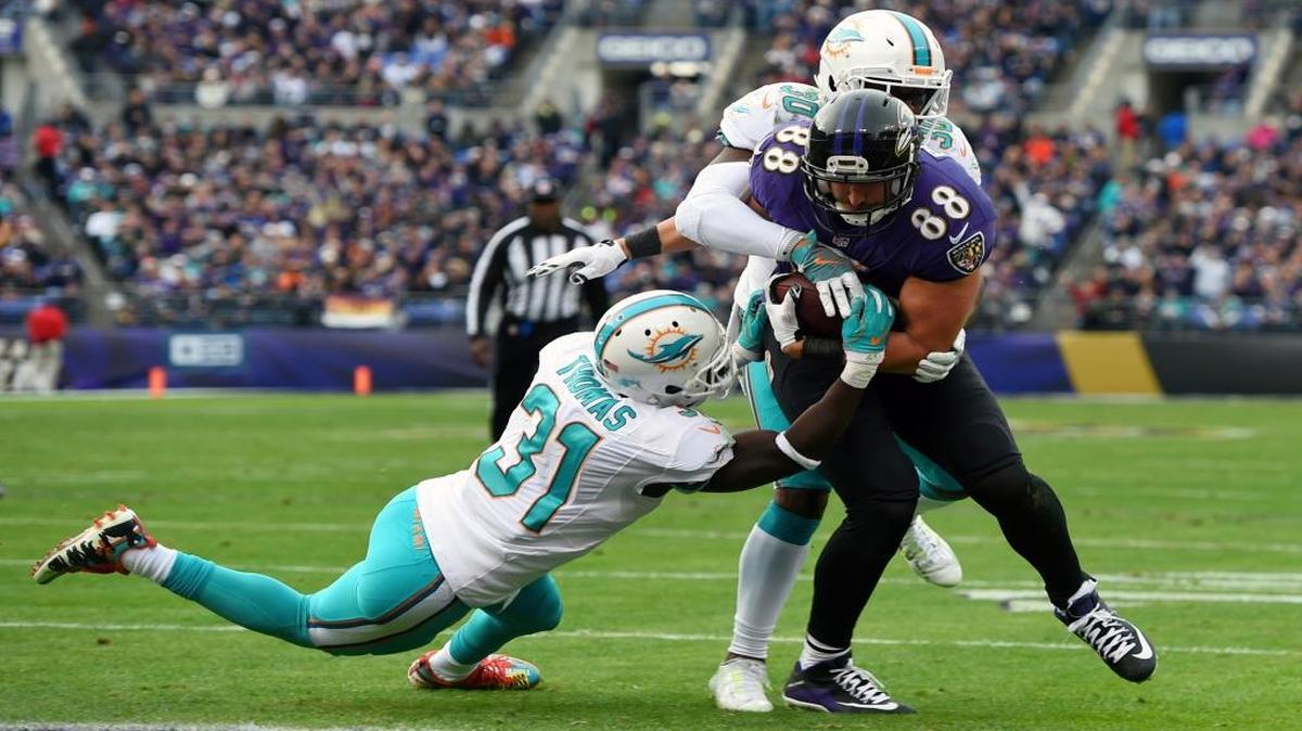Ravens tight end Dennis Pitta fights past Dolphins safeties Michael Thomas, left, and Bacarri Rambo for a touchdown, one of two touchdowns Pitta scored against Miami on Sunday.