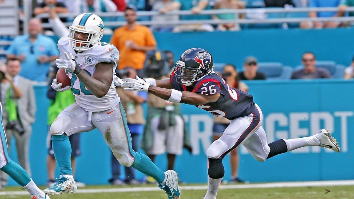Miami Dolphins Lamar Miller pulls away from Houston Texans Rahim Moore as Miller scores a touchdown in the second quarter at Sun Life Stadium in Miami Gardens, Florida, October 25, 2015.