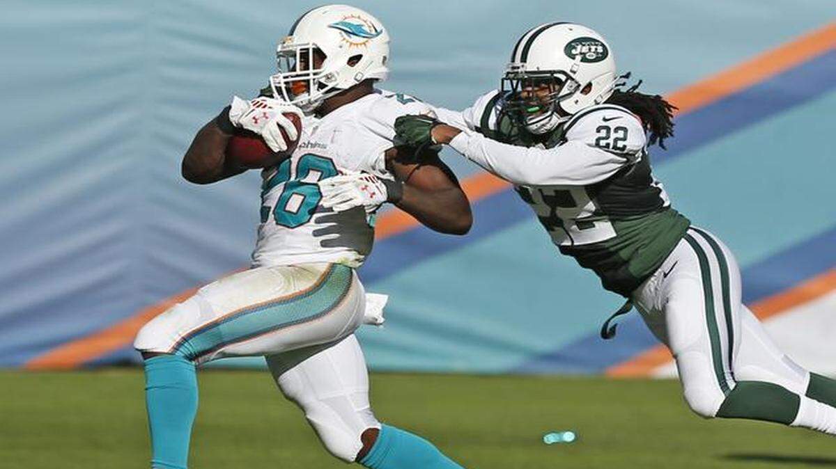 
Miami Dolphins running back Lamar Miller (26) scores on a 97-yard run in the third quarter as the Miami Dolphins host the New York Jets at Sun Life Stadium on Sunday, Dec. 28, 2014.
