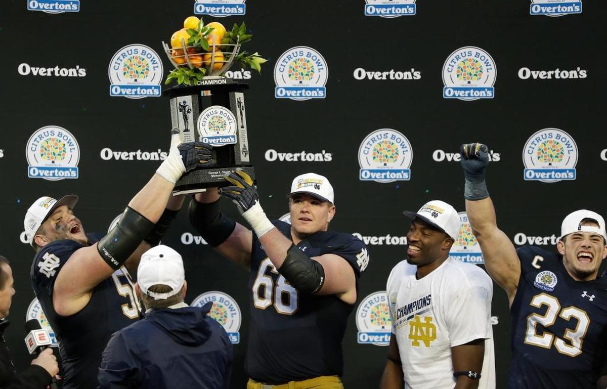 Notre Dame players, from left, Quenton Nelson, Mike McGlinchey, Miles Boykin and Drue Tranquill celebrate with the championship trophy after defeating LSU 21-17 in the Citrus Bowl NCAA college football game, Mon., Jan. 1, 2018, in Orlando, Fla.