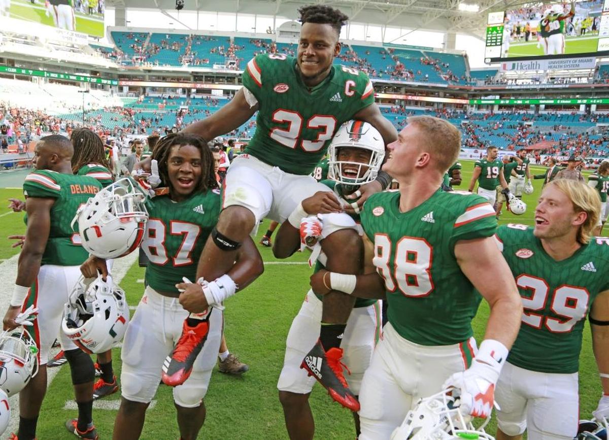 Miami Hurricanes tight end Christopher Herndon IV (23) is carried off by teammates after the University of Miami Hurricanes defeat the Virginia Cavaliers at Hard Rock Stadium on Sat., Nov. 18, 2017.
