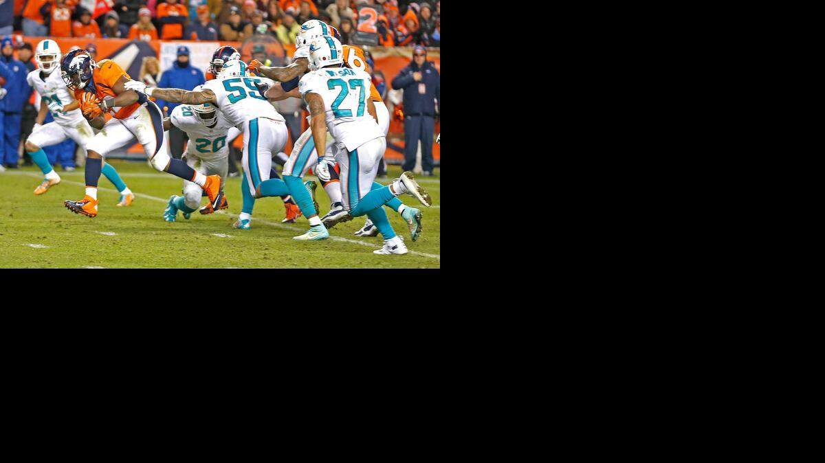 
The Miami Dolphins defense fails to stop Denver Broncos running back C.J. Anderson as he scores the winning touchdown in the a fourth quarter at Sports Authority Field at Mile High in Denver, Colorado, Nov. 23, 2014.
