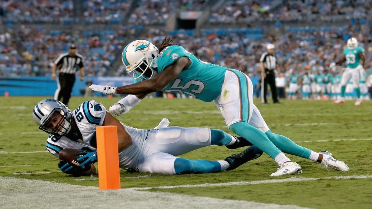 
CHARLOTTE, NC - AUGUST 22: Walt Aikens #35 of the Miami Dolphins stops Greg Olsen #88 of the Carolina Panthers from getting in the end zone during their game at Bank of America Stadium on August 22, 2015 in Charlotte, North Carolina.
