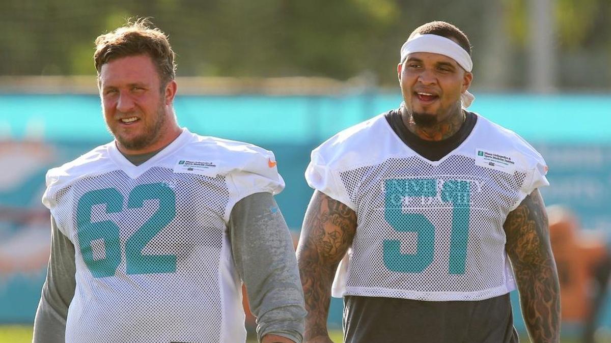 Miami Dolphins lineman Ted Larsen’s, left, contribution to the Dolphins’ Secret Santa gift exchange was a car - a 2000 Dodge Neon - and lineman Mike Pouncey claimed it for himself.