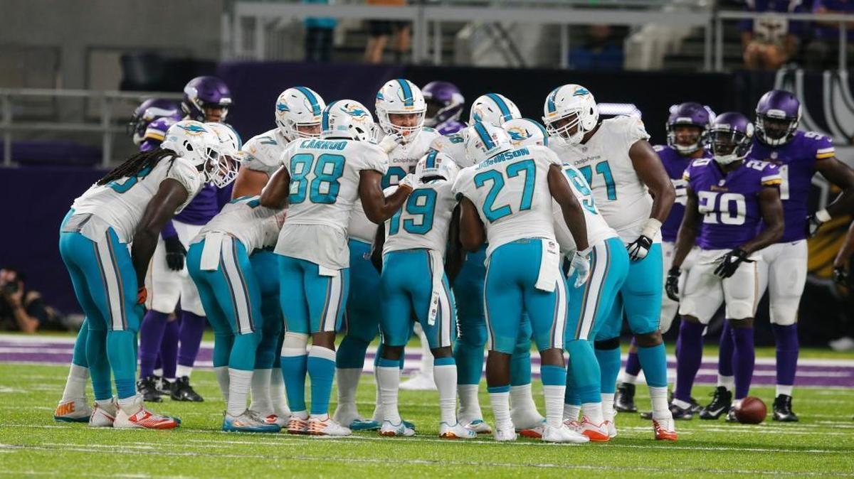 Miami Dolphins players stand in the huddle during the first half against the Minnesota Vikings on Thursday.