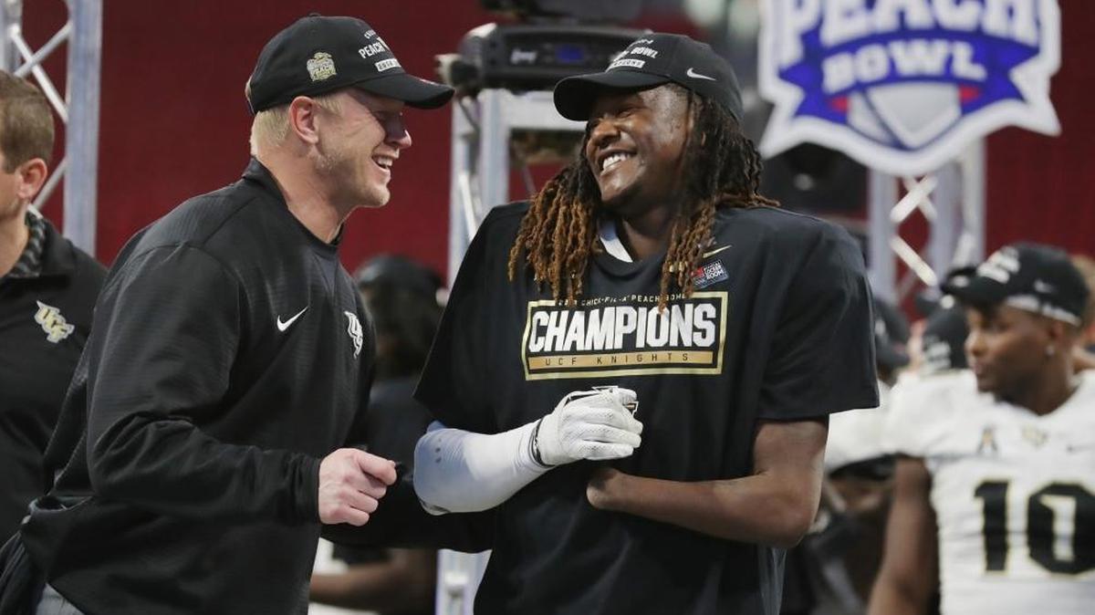 Coach Scott Frost of UCF Knights celebrates with Shaquem Griffin (18) after defeating Auburn to win the Chick-fil-A Peach Bowl at Mercedes-Benz Stadium.
