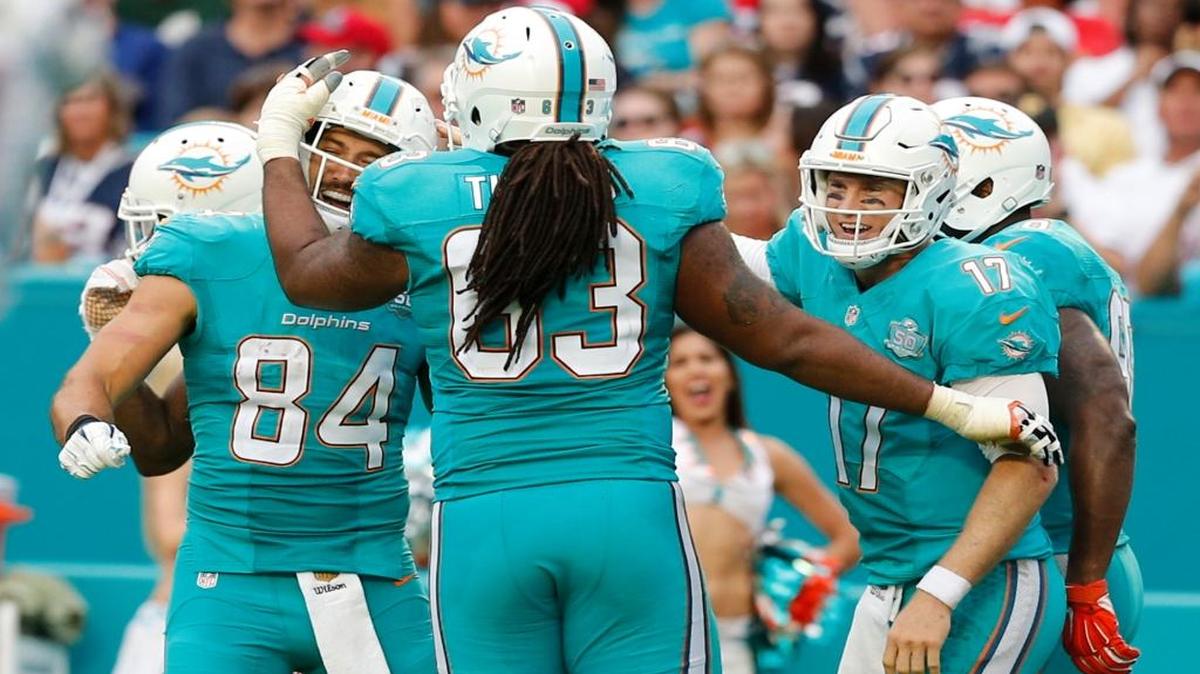 Miami Dolphins tight end Jordan Cameron celebrates a fourth quarter touchdown with offensive guard Dallas Thomas and quarterback Ryan Tannehill as the Dolphins host the New England Patriots at Sun Life Stadium in Miami Gardens on January 3, 2016.