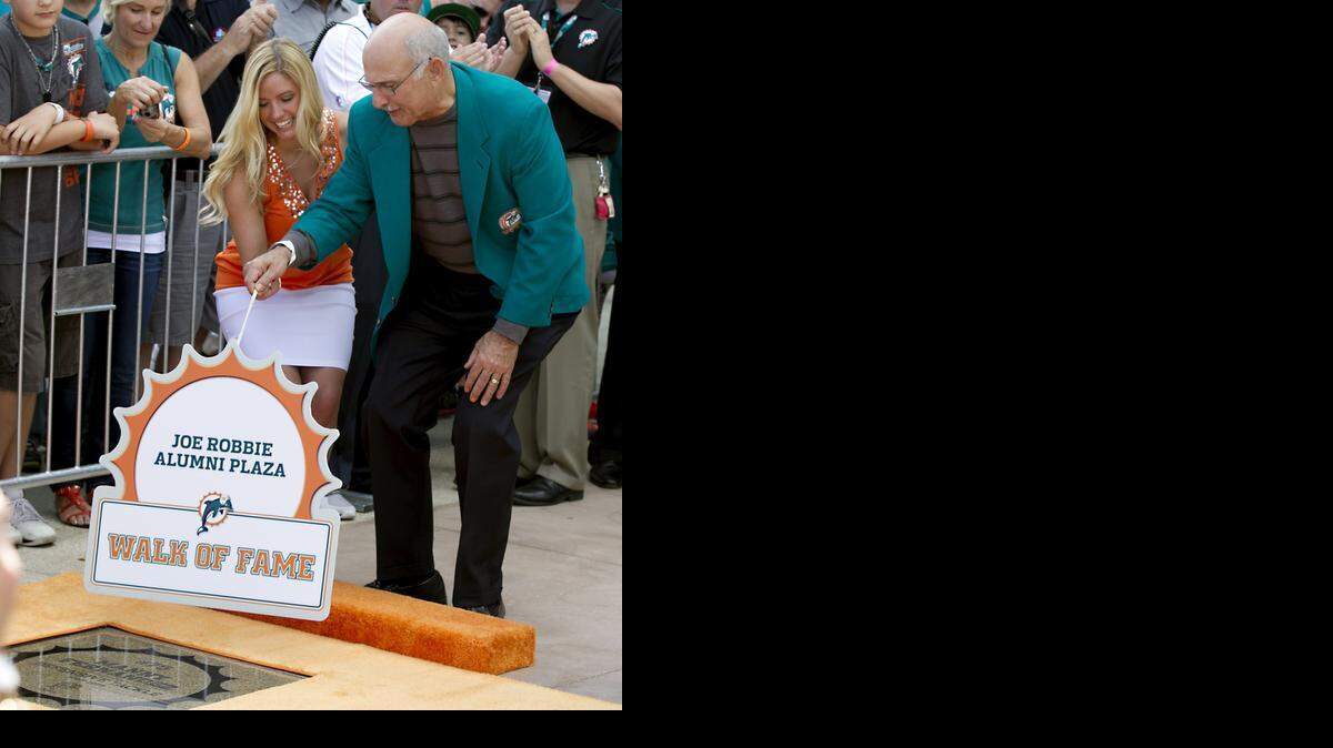 
Manny Fernandez, removing the cover off his Wall of Fame plaque in 2012, will become the 27th member of the Dolphins Honor Roll.
