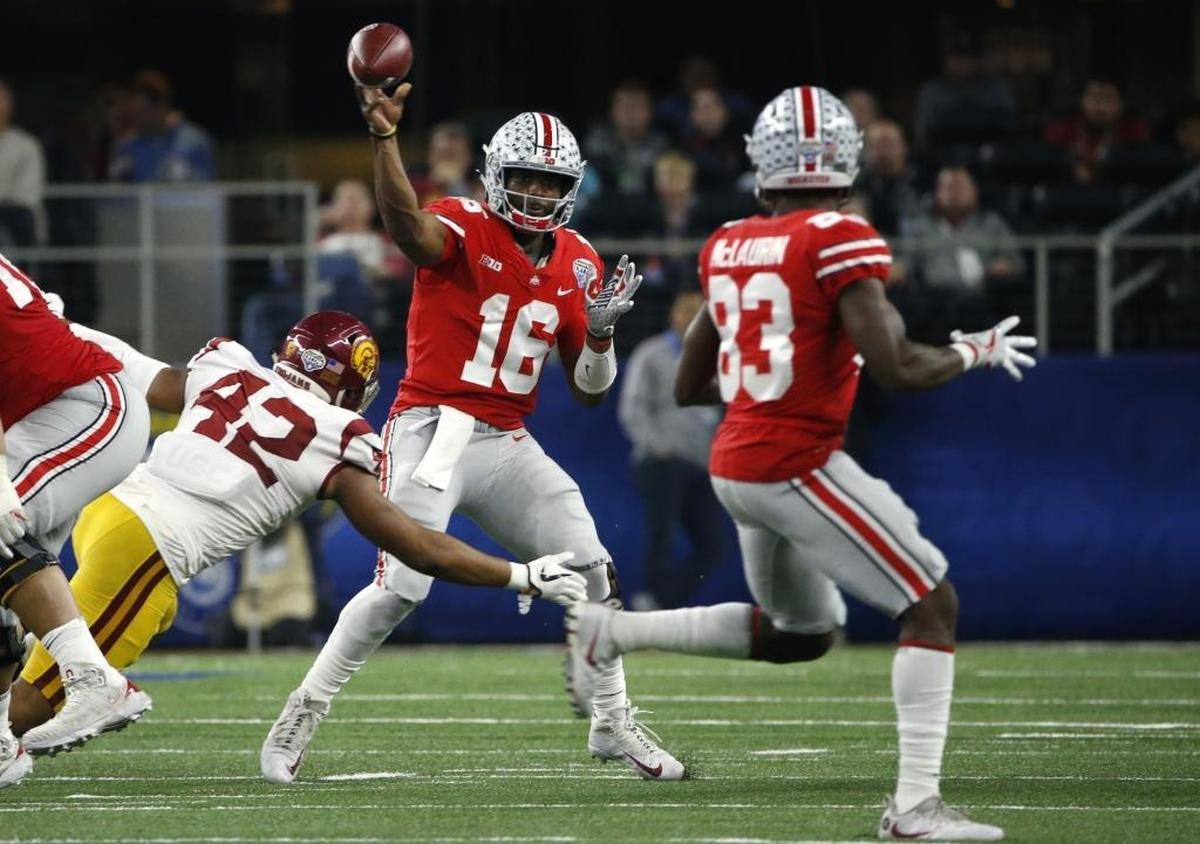 Ohio State Buckeyes’ J.T. Barrett, No. 16, throws while under pressure from USC Trojans’ Uchenna Nwosu, No. 42, during the Goodyear Cotton Bowl Classic at AT&T Stadium on Dec. 29, 2017 in Arlington, Texas. Ohio State won 24-7.