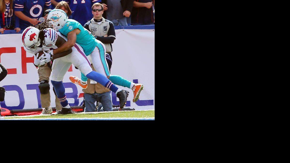 
Buffalo Bills wide receiver Sammy Watkins (14) scores a touchdown as he is tackled by Miami Dolphins cornerback Brent Grimes (21) during the second half of an NFL football game on Sunday, Sept. 14, 2014, in Orchard Park, N.Y. 
