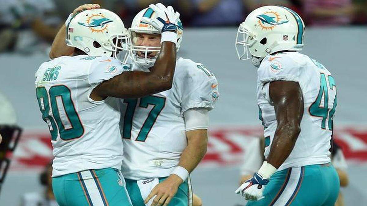 
Miami Dolphins’ Dion Sims, left, celebrates with Charles Clay, right, and Ryan Tannehill after scoring a touchdown against the Oakland Raiders at Wembley Stadium in London, Sunday, Sept. 28, 2014. 
