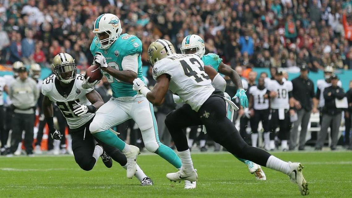 Miami Dolphins tight end Julius Thomas (89) runs between New Orleans Saints defensive back Rafael Bush (25) and free safety Marcus Williams (43) during the first half of an NFL football game at Wembley Stadium in London, Sun., Oct. 1, 2017.