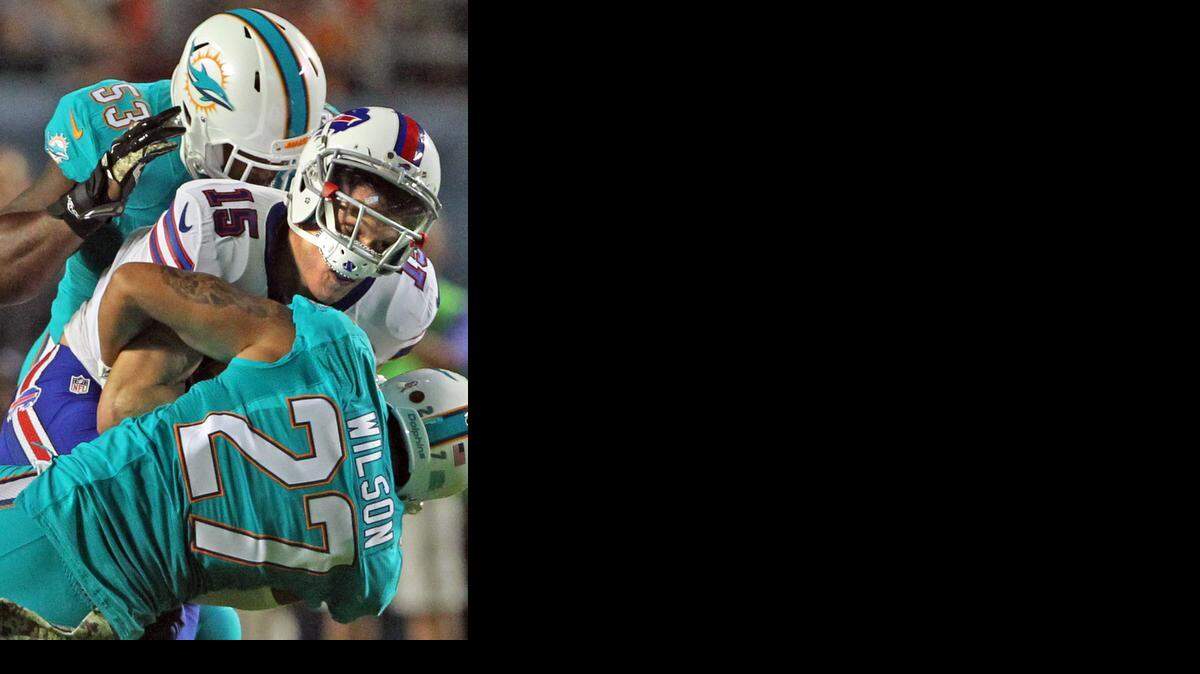 
Miami Dolphins linebacker Jelani Jenkins (53) and safety Jimmy Wilson squeeze Buffalo Bills receiver Chris Hogan after a reception in the first quarter at Sun Life Stadium in Miami Gardens, on Thursday, Nov. 13, 2014.
