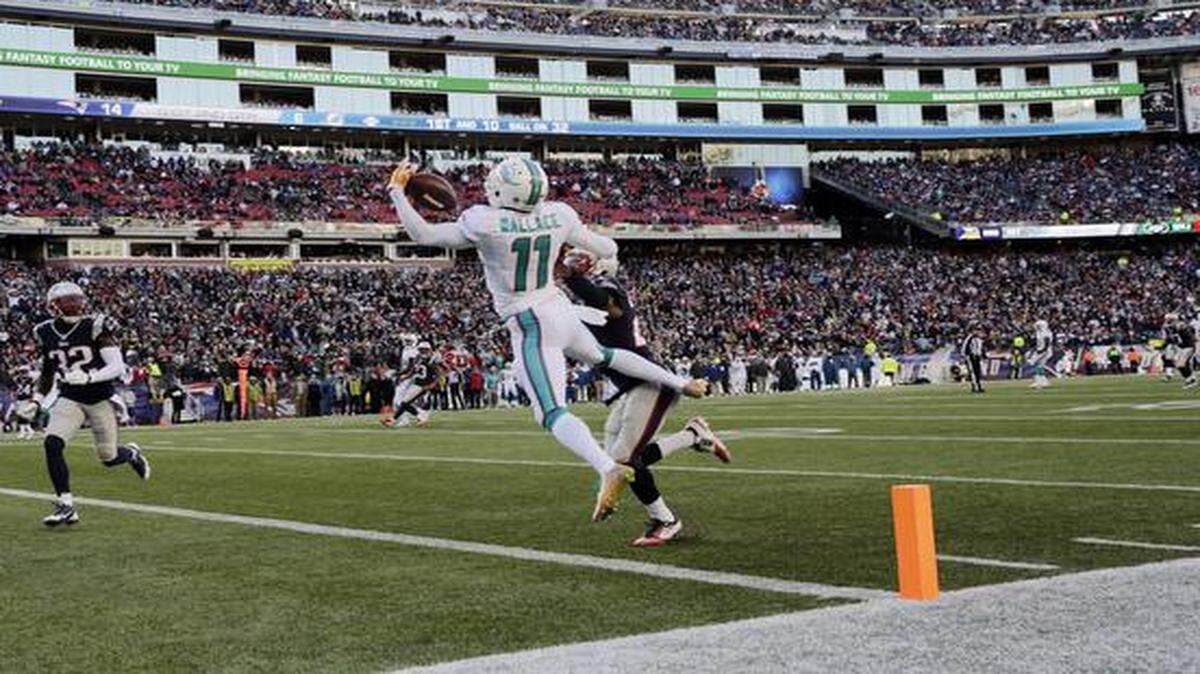 
Miami Dolphins wide receiver Mike Wallace (11) catches a touchdown pass in front of New England Patriots defensive back Malcolm Butler, right rear, and safety Devin McCourty (32) in the first half of an NFL football game, Sunday, Dec. 14, 2014, in Foxborough, Mass. 
