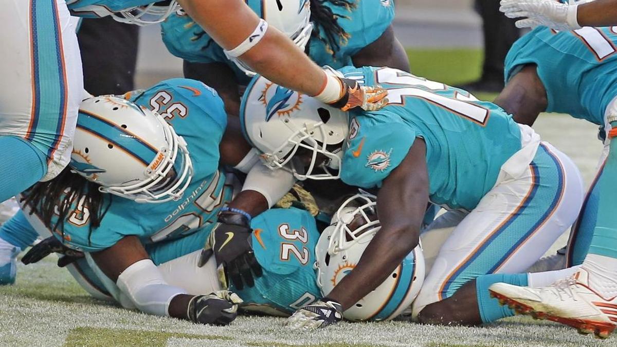 Miami Dolphins Jakeem Grant and, 19, and Tony Lippet, 35, pile onto Kenyan Drake, 32, after Drake scored a fourth quarter touchdown as they play the New York Jets at Hard Rock Stadium in Miami Gardens, Florida on Sun., Nov. 6, 2016.