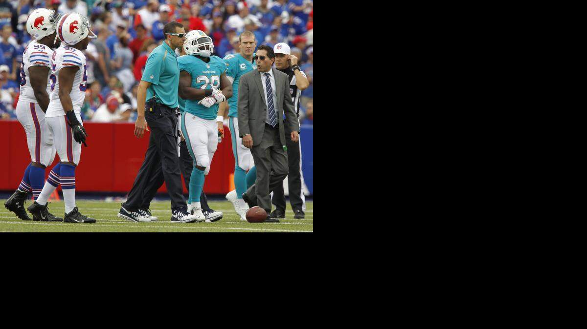 
Miami Dolphins running back Knowshon Moreno (28) is led off the field after getting injured in the first quarter as the Buffalo Bills host the Miami Dolphins at Ralph Wilson Stadium on Sunday, September 14, 2014 in Buffalo, N.Y. The Bills beat the Dolphins 29-10. 
