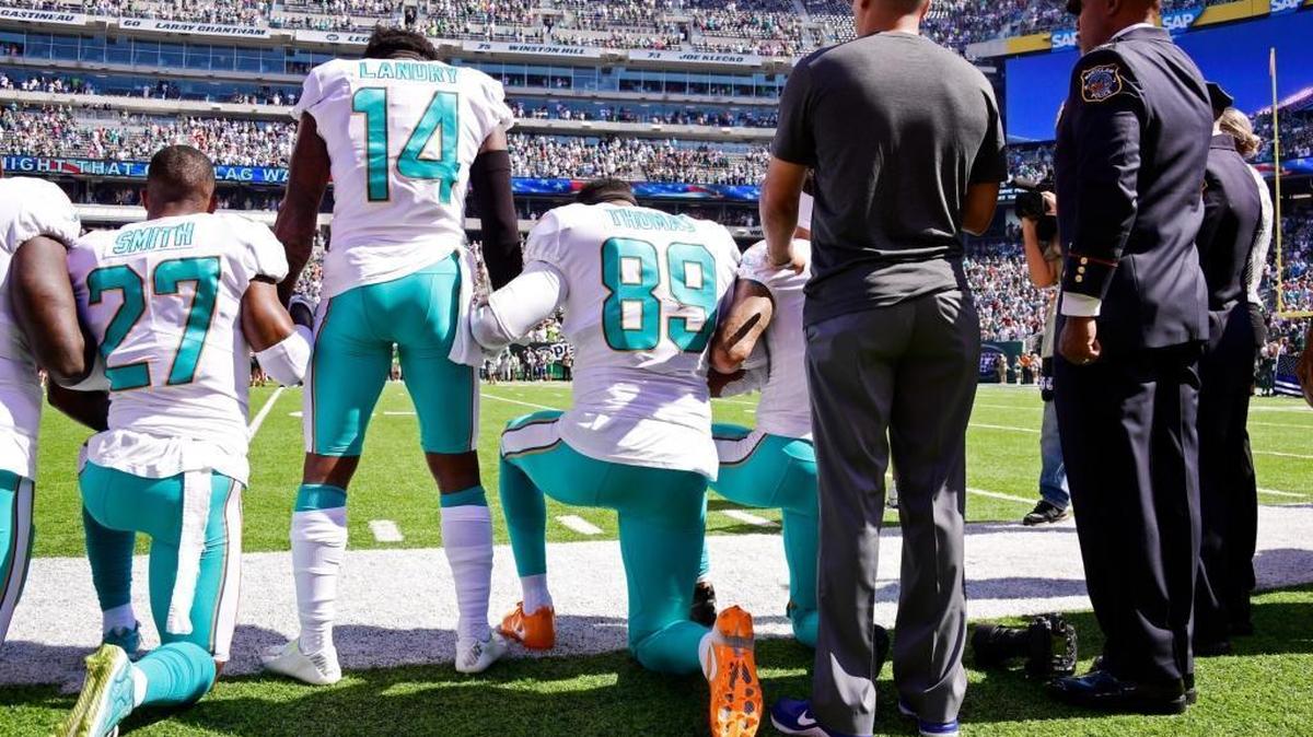 Dolphins Maurice Smith (27), Julius Thomas (89) and Jarvis Landry (14) during the national anthem prior to the Dolphins 20-6 loss to the New York Jets at MetLife Stadium on Sept. 24.