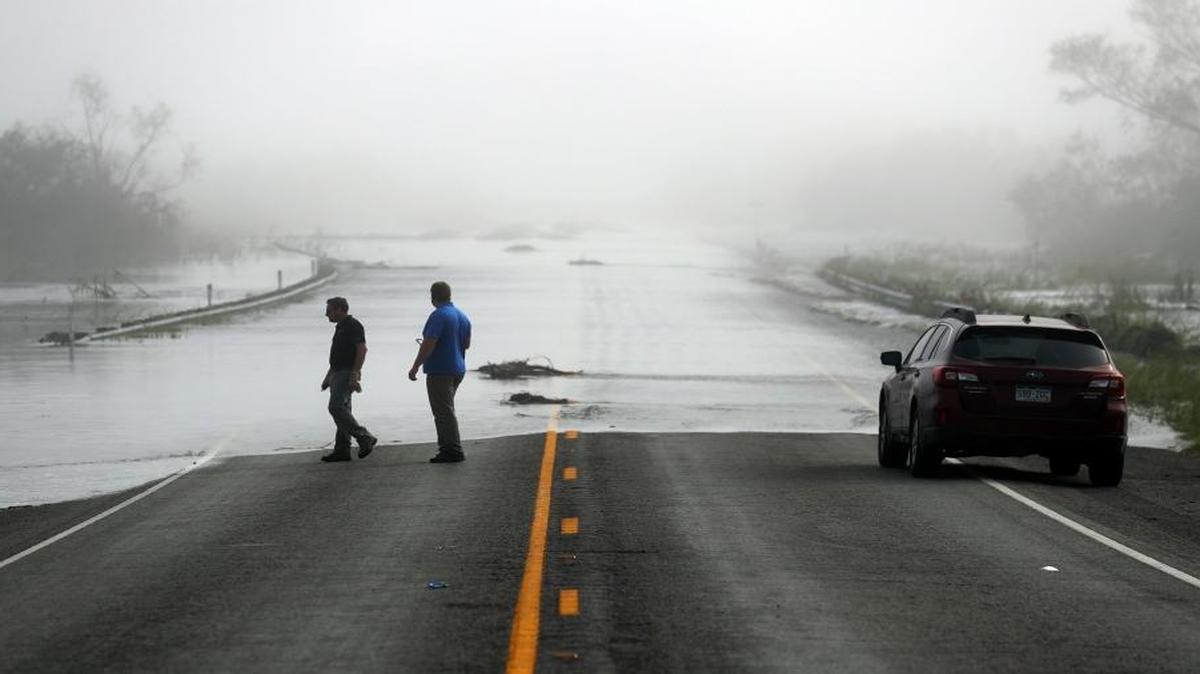 Motorists watch as flood waters from the Guadalupe River spill over Texas Highway 35 Friday in Tivoli, Texas.