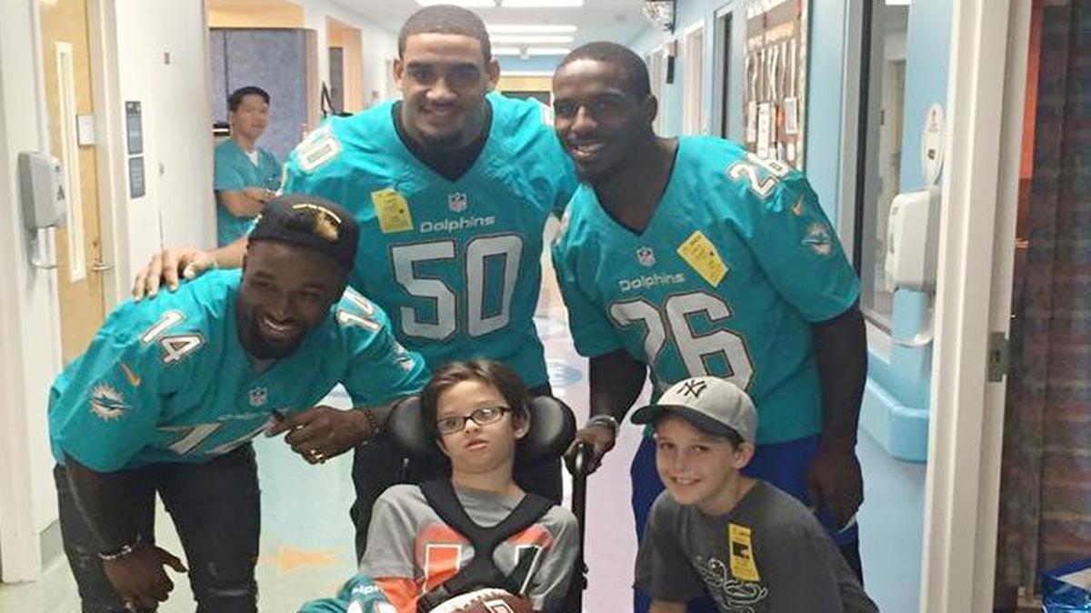 
In this photo tweeted by Miami Dolphins Lamar Miller, Dolphins players, from left: Jarvis Landr; Olivier Vernon; and Lamar Miller pose for a photo during a visit to see Peyton McCaughey (in wheelchair) Sunday, Sept. 6, 2015, at Joe DiMaggio Children’s Hospital in Hollywood, Fla. McCaughey is the Palm Beach County boy who became mysteriously ill after returning to the home his parent had tented and fumigated by a pest control company. Other boy is unidentified.
