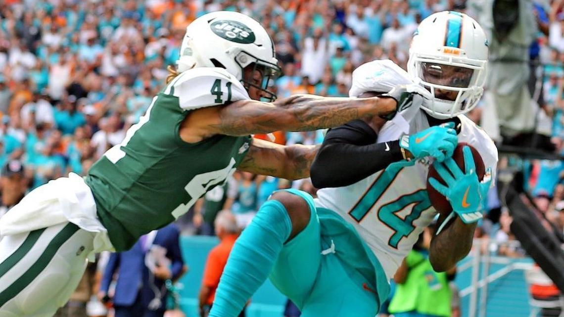 Miami Dolphins Jarvis Landry (14) catches a touchdown pass as New York Jets Buster Skrine (41) fails to stop his catch in the first quarter at Hard Rock Stadium in Miami Gardens, Florida, October 22, 2017.