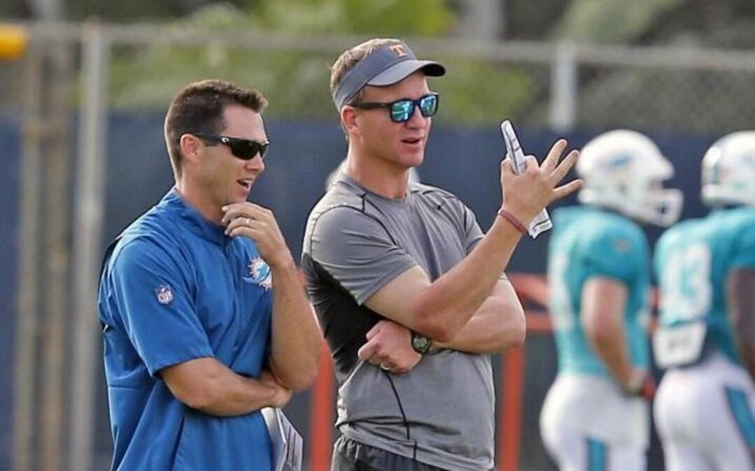Dolphins director of player personnel Joe Schoen talks with Peyton Manning at Dolphins training camp last summer.
